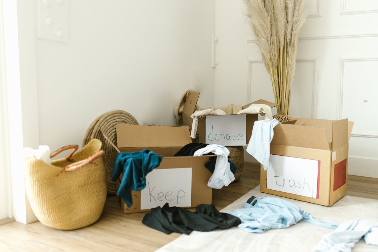 about-me-img Cardboard boxes labeled 'Keep', 'Donate', and 'Trash' for home decluttering.
